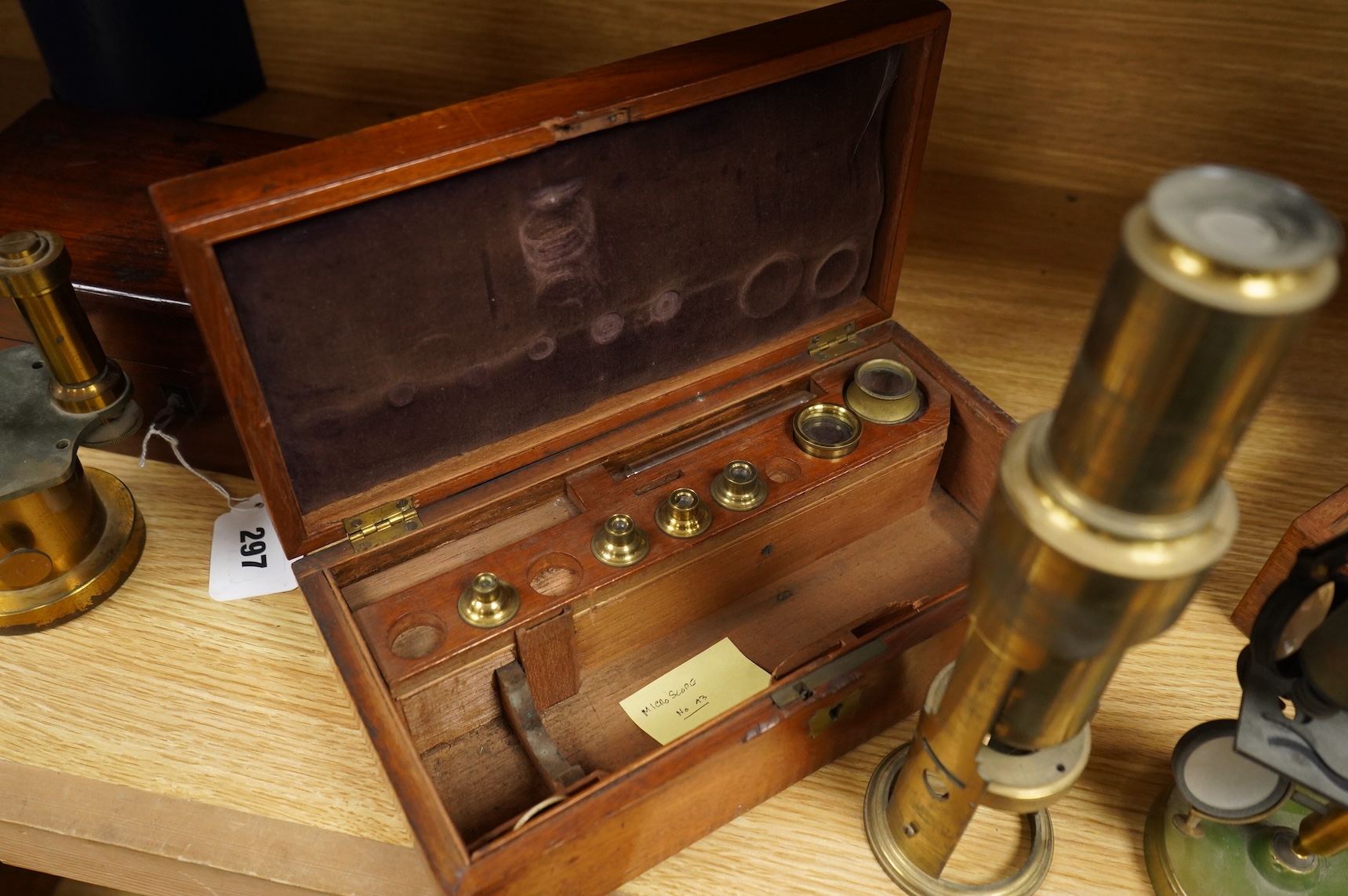 Two microscopes; an early 19th century Martin type brass compound monocular microscope, with five numbered objectives, specimen tube and hand magnifier, mahogany case 27cm wide, together with a late 19th/early 20th centu